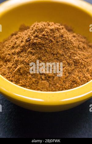 Ras-el-harnout (North African spice mixture), in small yellow bowl - Stock Photo