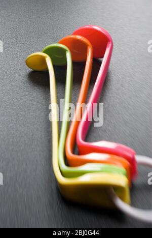 Set of brightly coloured melamine plastic measuring spoons - Stock Photo