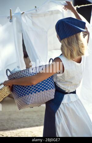 Hanging out the laundry on washing line in sunshine with a breeze - Stock Photo