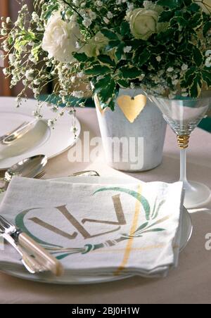 Specially stencilled napkins as part of table setting for wedding reception - Stock Photo