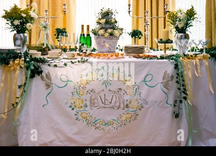 Wedding table, with printed design, ivy swags, and floral decorations - Stock Photo