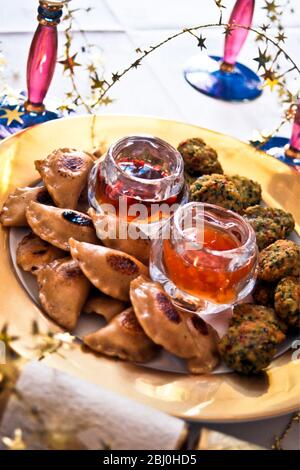 Indian snacks as party canapes with sweet hot sauce - Stock Photo