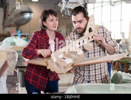 Team of aircraft enthusiasts working in workshop on creating of airplane models Stock Photo