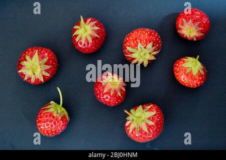 Black plate with red strawberries - Stock Photo