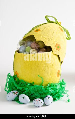 A box of decorative Easter egg decorations on a yellow surface Stock ...