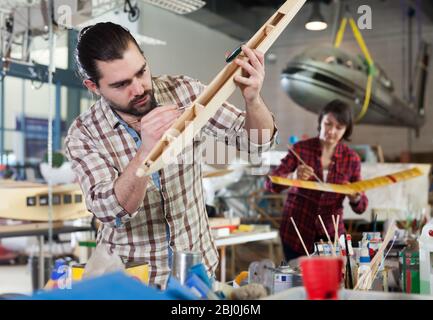 Lucky male aircraft enthusiast working in workshop on creating of airplane models Stock Photo