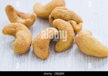 Slated cashew nuts in small pile in white surface - Stock Photo