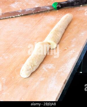 Gnocchi dough rolled out into 'sausage' shape and divided into two - Stock Photo