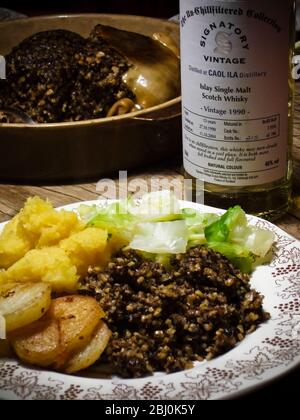 Haggis with superior whisky for Burns night, served with traditional accompaniment of 'bashed neeps' (mashed swede) but with the addition of sauteed p Stock Photo