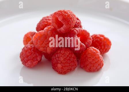 Fresh whole raspberries on white plate Stock Photo - Alamy