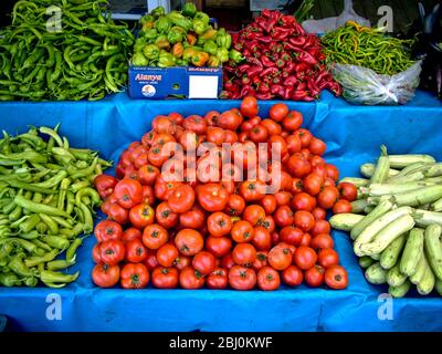 Selection of fresh vegetables - tomatoes, cucumbers and several varieties of peppers on market stall outside shop in Dalayan, Anatolia, southern Turke Stock Photo