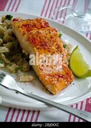 Spiced grill salmon fillet on rice pilaf with lime wedge - Stock Photo