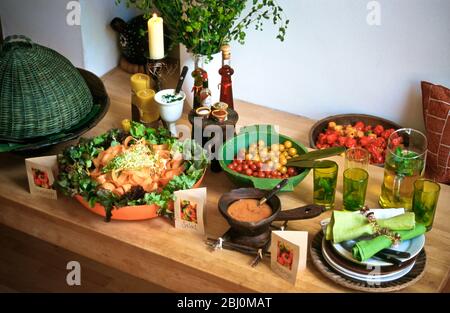 Carrot, pepper and tomato salads in bright bowls and baskets for a buffet lunch party - Stock Photo