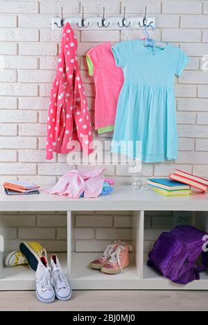 Children things hanging on wall and stacked in room Stock Photo