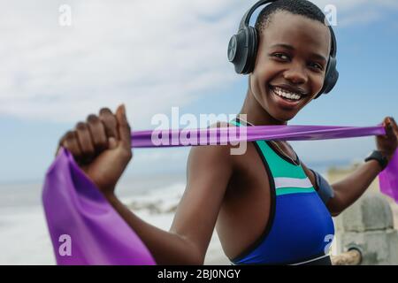 Fit woman exercising with a resistance band outdoors. Fitness female training using a resistance band. Stock Photo