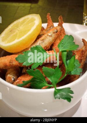 Deep fried whitebait, with lemon wedge and mayonnaise, garnished with flat parsley. - Stock Photo