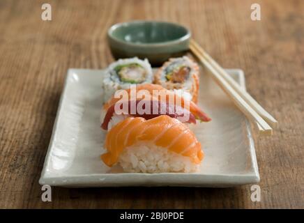 Plate of Japanese sushi pieces with chopsticks and bowl with wasabi and soy - Stock Photo