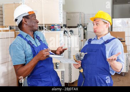 Professional male contractors discussing while determining scope of building work indoors Stock Photo