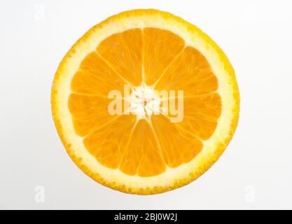 Cut face of half orange against white background - Stock Photo