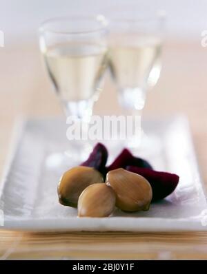 Pickled onions and beetroot pieces as accomopaniment to chilled white wine as an hors d'ouevre - Stock Photo