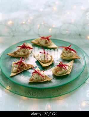 Party tray of canapes, home made houmous on toasted pitta with strips of red pepper - Stock Photo