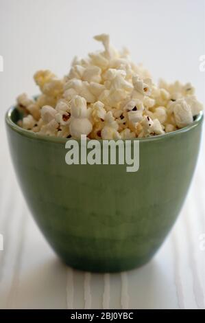 Popcorn in green pottery bowl - Stock Photo