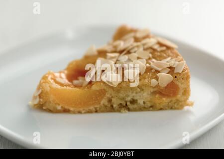 Slice of apricot cake on small white plate - Stock Photo