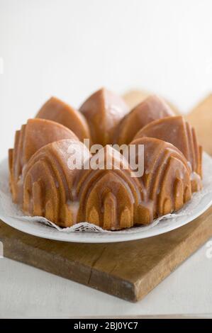 Classic pound cake baked in cathedral style Bundt tin, with sugar glaze - Stock Photo