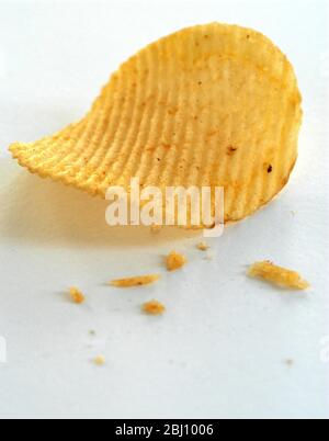 Crinkled potato crisps on white background - Stock Photo