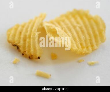 Crinkled potato crisps on white background - Stock Photo