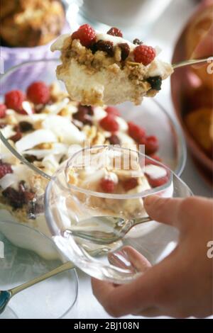 A portion of trifle being sppooned into glass bowl - Stock Photo