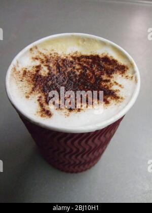 Cardboard cup of cappucino coffee bought from station coffee shop to be drunk on train - Stock Photo