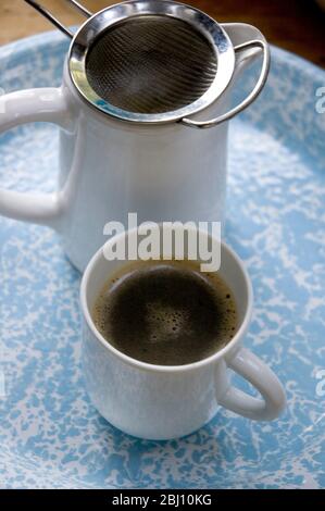 Real coffee made simply in jug with tea strainer - Stock Photo