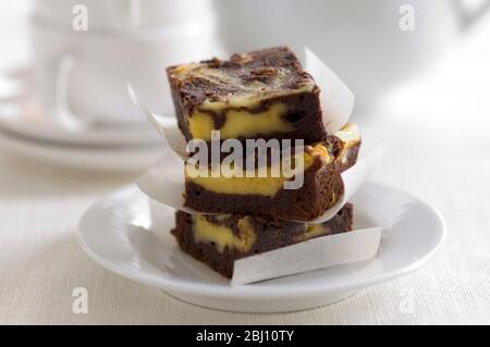 Stacked squares of cheesecake marbled with chocolate - Stock Photo