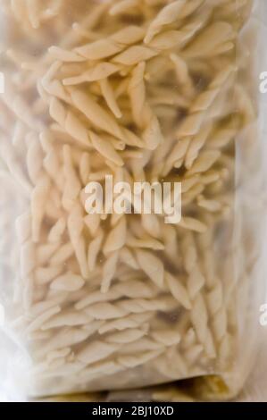 Closeup of trofie twisted pasta shapes in packet - Stock Photo