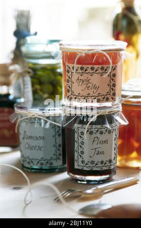 Collection of decoratively packaged jars of fruit jellies and jams - Stock Photo