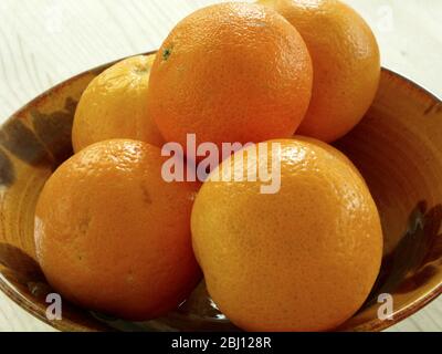 Ceramic bowl with five fresh oranges - Stock Photo