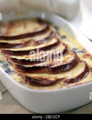 Classic bread and butter pudding in white ovenproof dish - Stock Photo