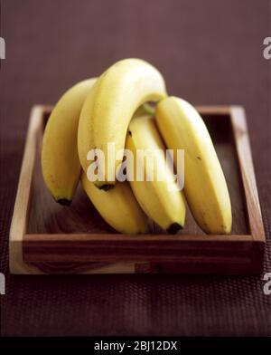 Bunch of bananas on wooden tray - Stock Photo