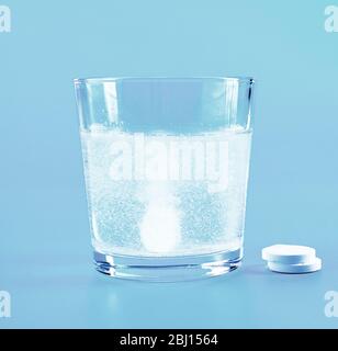 Glass of water and pills on blue background Stock Photo