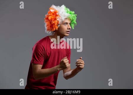 young man wearing tricolour wig looking with curiosity, independence day Stock Photo