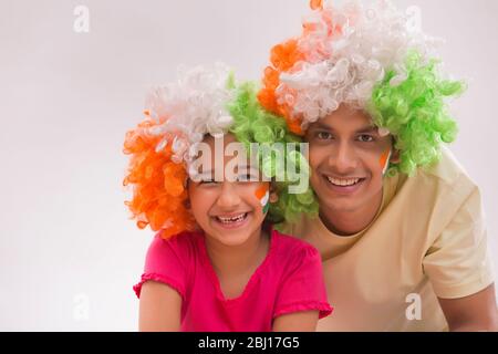 young man and girl wearing tricolour wigs and smiling, independence day Stock Photo