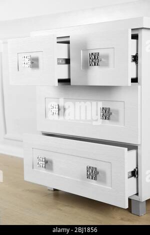 White wooden chest of drawer in the interior of an room.  Open drawers Stock Photo