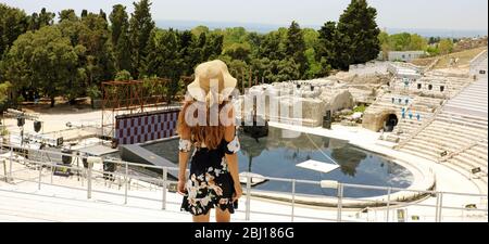 Panoramic banner view of young woman in Syracuse (Siracusa) Greek theatre, Sicily, Italy Stock Photo