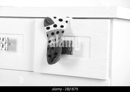 White wooden chest of drawer with sock in opened drawer Stock Photo