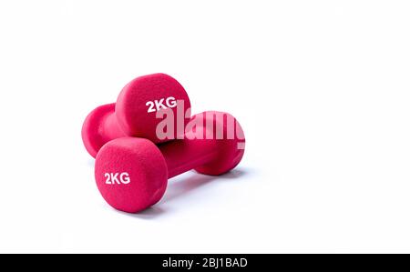 Set of red dumbbells isolated on white background. A pair of red neoprene dumbbells. Home gym equipment for exercise at home. Weight training Stock Photo