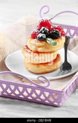 Fritters of cottage cheese with berries in plate, closeup Stock Photo