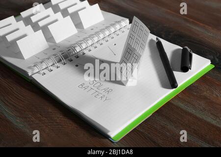 Applique paper with building and solar panels in notebook Stock Photo