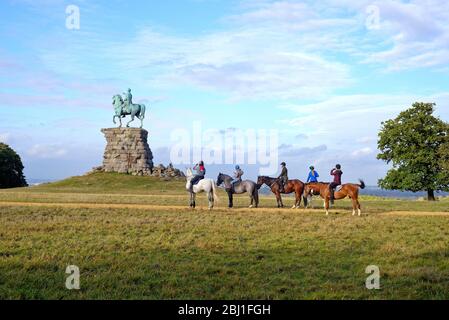 Horse riders approaching the Copper Horse equestrian statue of King George third, Snow hill Windsor Great Park Berkshire England UK Stock Photo