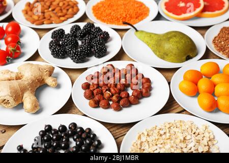 Different products on saucers on wooden table close up Stock Photo